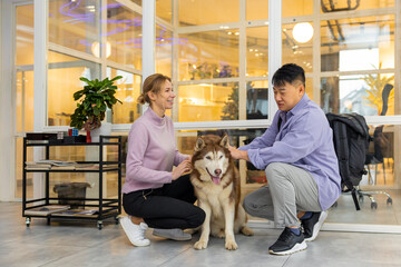 Two colleagues in a coworking area with a dog