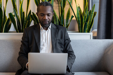 African american businessman working on a laptop and looking serious