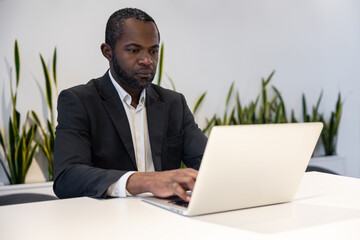 Businessman working on a laptop and looking busy and thoughtful
