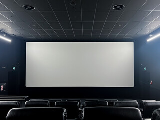 Spacious modern cinema hall featuring comfortable black leather seats and a large blank screen, ready for an immersive film viewing or presentation