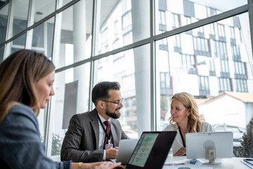 Businesspeople working together on laptops in modern office