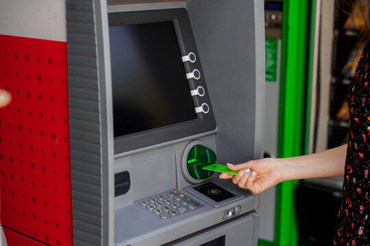 Woman Using ATM with Green Bank Card