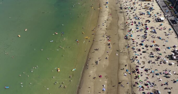 Busy Beach in the Summer With White Sand and Shallow Clear Water