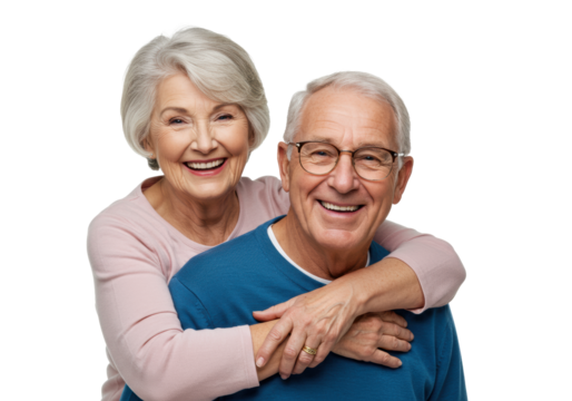 Elderly caucasian woman with grey hair in pink top embracing elderly caucasian man with grey hair in blue sweater and glasses, both smiling broadly on transparent studio background with copy