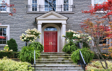 Stone house with portico entrance and maroon colored double door