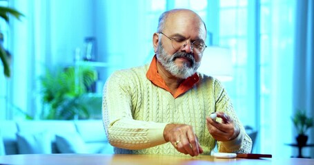 Indian senior man checking sugar level at home using handheld glucometer device, smiling happily after seeing normal reading, calling someone joyfully on smartphone to share positive health update - Powered by Adobe