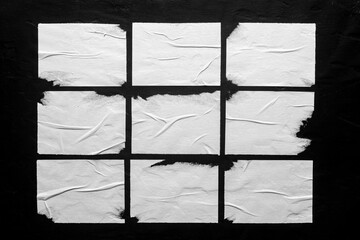 Several white posters with folds on a black background.