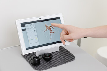 Doctor using innovative tablet for muscle treatment