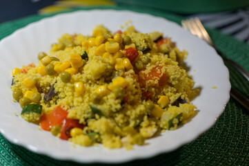 A plate of food with a fork and knife on a green tablecloth
