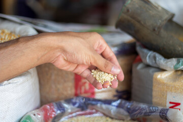 A man holds some Lentils in a sack