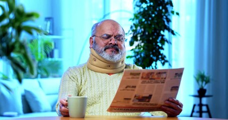 Indian senior man reading newspaper with tea at home at table, relaxed elderly person enjoying peaceful morning routine, sipping hot beverage while staying updated on news in cozy domestic setting