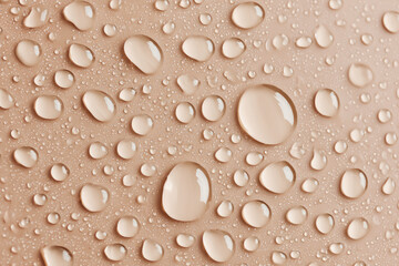 Water drops on beige background. Clear liquid toner serum droplets texture