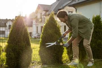 Man in the garden working with the prune and looking involved