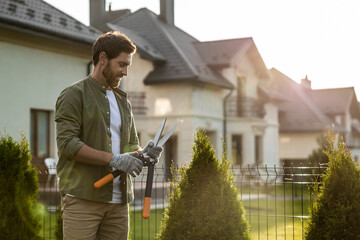 Confident young bearded man wording in the garden and looking resolute