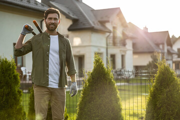 Confident young bearded man wording in the garden and looking resolute