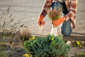 Woman in plaid shirt working in the garden and looking involved