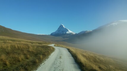 Scenic drive toward snowy mountain peak under blue sky