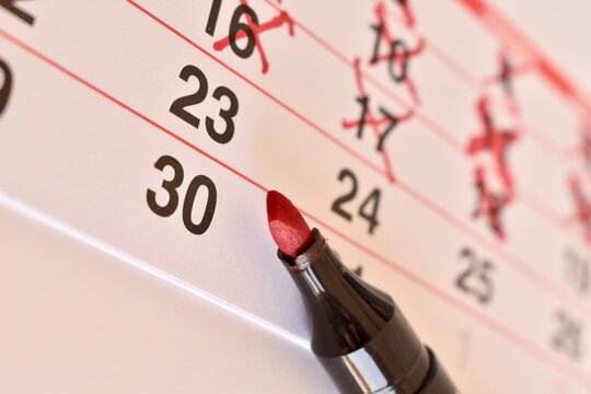 Days crossed off with a marker on a wall calendar, leading up to a special event. Concept of waiting and preparation.