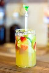 Refreshing lemonade with strawberries and lime served in a jar with a straw