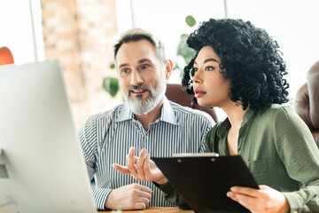 Professional collaboration between diverse coworkers in a stylish office environment discussing a...