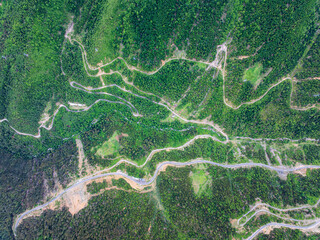 Aerial View of Winding Mountain Roads and Green Valleys