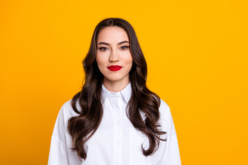 Portrait of a young professional woman in a white shirt on a vibrant yellow background, exuding...