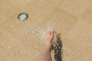 Foot splashing in refreshing water on a sunny day at a public water play area