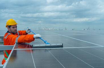 Front view profession engineer or technician worker use cleaning brush to clean solarcell panel in...