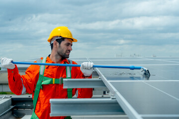 Side view of profession engineer or technician worker use cleaning brush to clean solarcell panel...