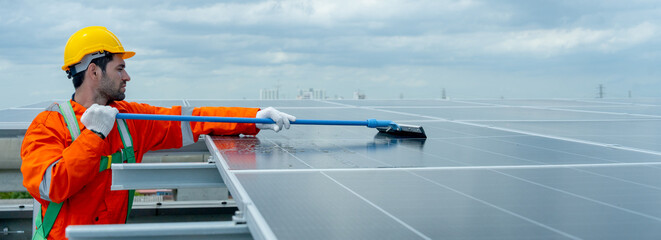 Wide shot of profession engineer or technician worker use cleaning brush to clean solar cell panel...