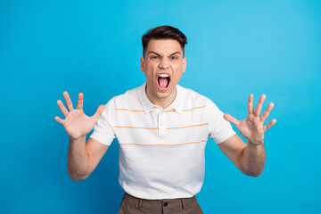 Young man expressing frustration against a blue background showcasing intense emotions with hands raised in a gestural pose