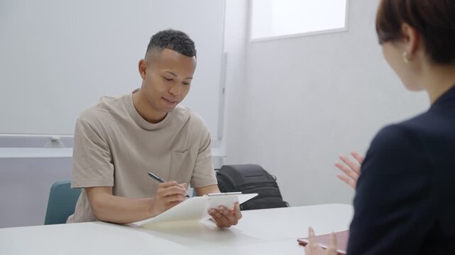 手続きをする外国人労働者とスタッフ