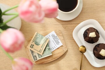 Tips, receipt and order on wooden table, flat lay