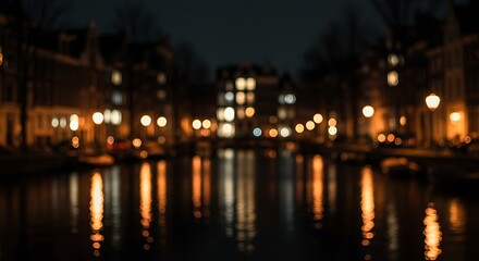 Fototapeta premium Nighttime canal scene with blurred lights reflecting on water, showcasing Amsterdam's architecture.