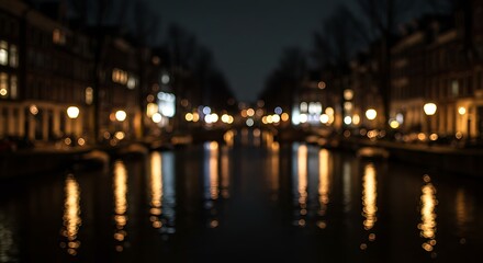 Nighttime canal view in a European city, showcasing illuminated buildings and reflections.