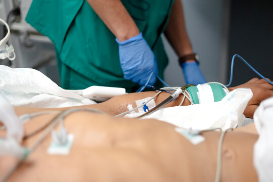 Doctor connecting electrodes to patient leg for monitoring vital signs - Powered by Adobe