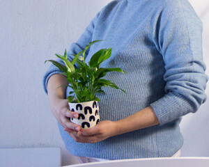 Future mother with a plant i her hands