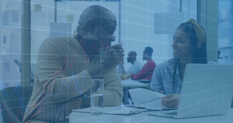 Discussing senior man and woman reviewing documents at office table with data charts overlay