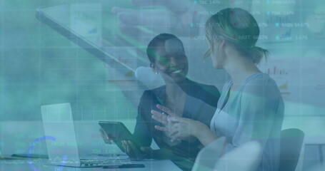 Analyzing metrics two business professionals studying charts at conference table with tablet laptop