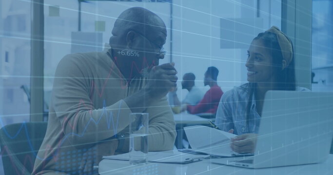 Discussing senior man and woman reviewing documents at office table with data charts overlay - Powered by Adobe