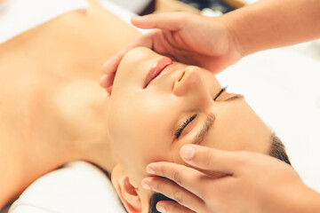 Closeup woman enjoying relaxing anti-stress head massage and pampering facial beauty skin...