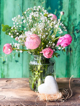 Beautiful bouquet of spring flowers with heart on wooden background - greeting card for Happy Mothers Day, Birthday, Wedding	

