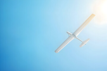 Glider soaring through clear blue sky on a sunny day, aerial view of sailplane in flight