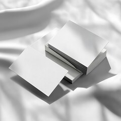 Stack of blank white business cards on white fabric