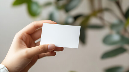 Person holding business card mockup on neutral background, identity focus