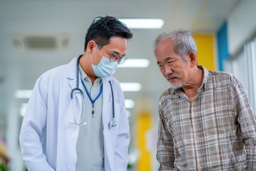 Fototapeta premium Asian male physician comforting elderly male patient during hospital visit