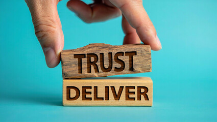 Fingers place a wooden block with the word trust on top of another block with the word deliver