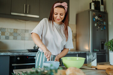 Young caucasian woman making bread dough with rolling pin and flour	
