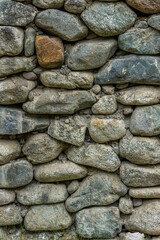 Rustic stone wall made of various rocks outdoors in nature