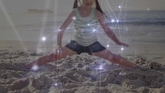Child planting feet on sand activating fitness network overlay stretching into split